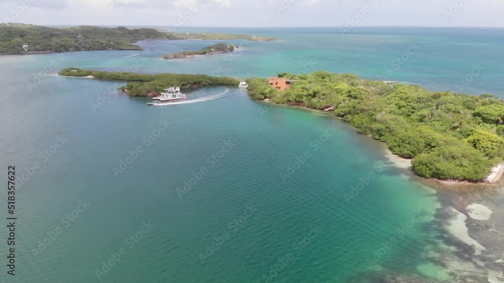 Aerial view flying over a caribbean island with bungalows surrounded by tropical trees in Baru, Cartagena, Colombia Aerial view flying over a caribbean island with bungalows surrounded by tropical trees in Baru, Cartagena, Colombia