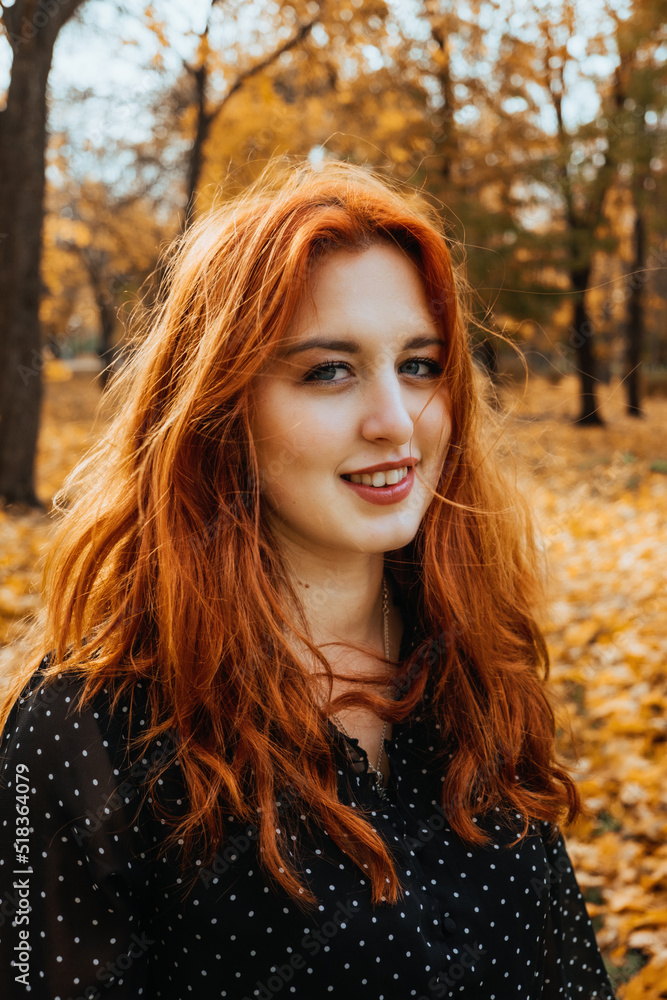 Autumn portrait of candid beautiful red-haired girl with fall leaves in hair. Autumn portrait of candid beautiful red-haired girl with fall leaves in hair.