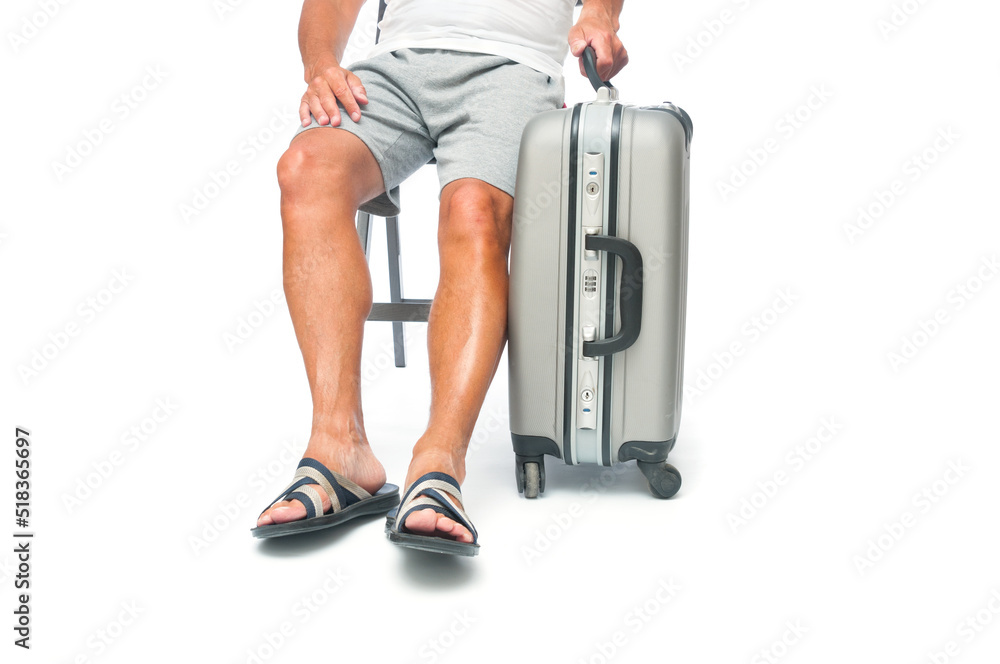 Traveler man in shorts with travel suitcase sitting in a chair on white background Traveler man in shorts with travel suitcase sitting in a chair on white background