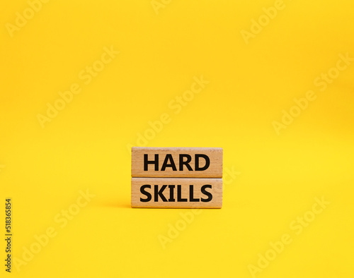 Hard skills symbol. Wooden blocks with words Hard skills. Beautiful yellow background. Businessman hand. Business and Hard skills concept. Copy space