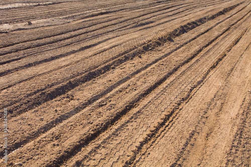 Texture brown yellow clay earth with traces of cars, trucks, tractors. Road with tire tracks. Texture brown yellow clay earth with traces of cars, trucks, tractors. Road with tire tracks.