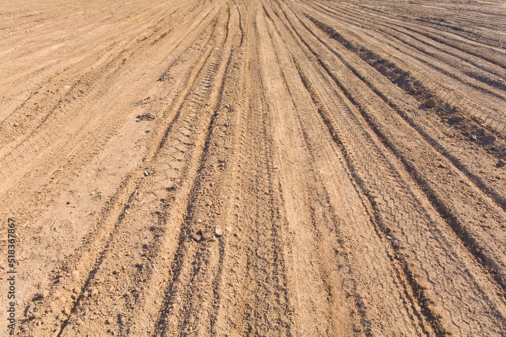Texture brown yellow clay earth with traces of cars, trucks, tractors. Road with tire tracks. Texture brown yellow clay earth with traces of cars, trucks, tractors. Road with tire tracks.