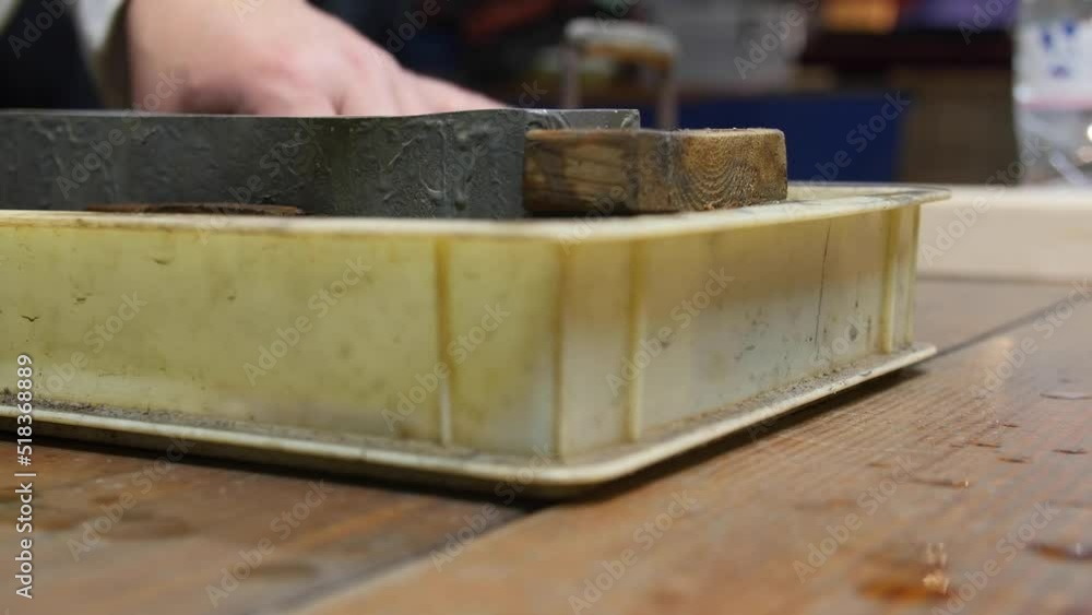 Master swordsmith is sharpening knife on grindstone with water Master swordsmith is sharpening knife on grindstone with water