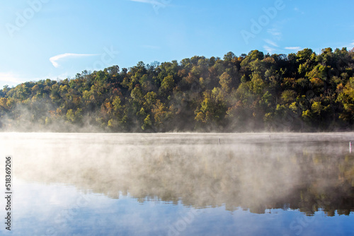 Fog over a lake with a forest in the background