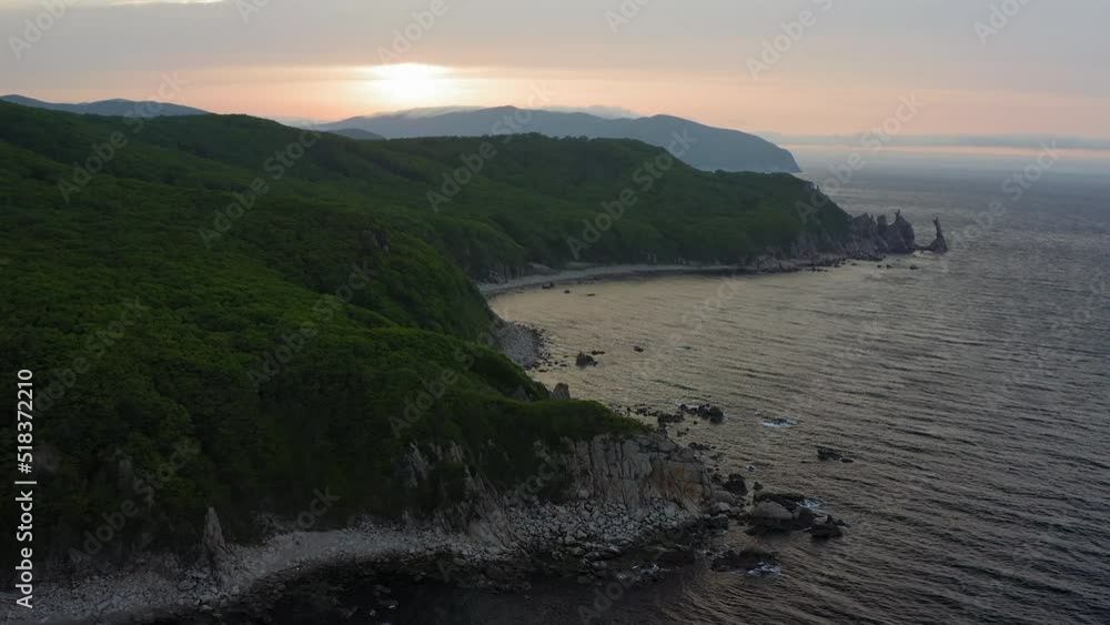 Sea stack vertically sticking out of the water at dawn. Drone view, panoramic view. Cape Laplace, East Sea Sea stack vertically sticking out of the water at dawn. Drone view, panoramic view. Cape Laplace, East Sea