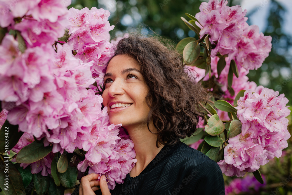 Portrait of a beautiful curly woman enjoying rhododendrons Portrait of a beautiful curly woman enjoying rhododendrons