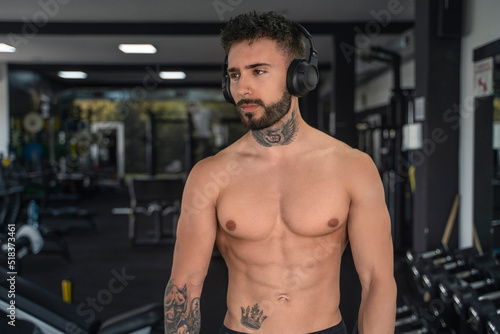 Handsome male with tattoos in his 20s in the gym