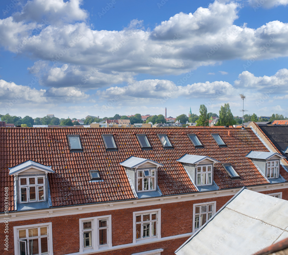 Oldwindow. Rooftop view of buildings in a town with glass windows and frames under a cloudy blue sky. Beautiful landscape architecture with clouds surrounding a suburban urban environment.