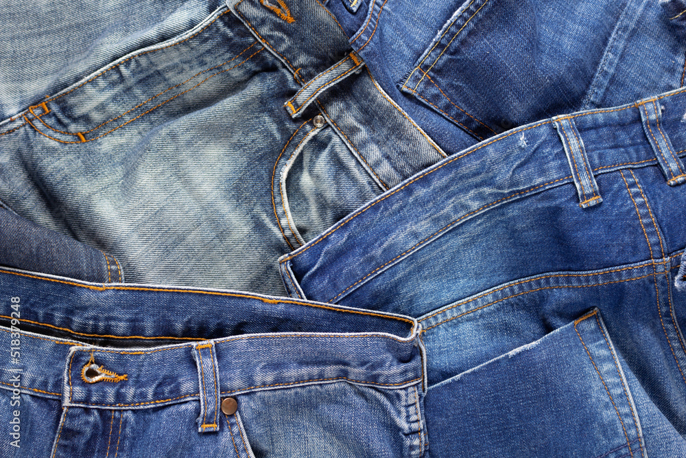 Blue jeans denim heap background. Jeans fabric as material surface