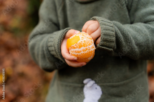 Little girl eating fruit, healty snack outdoors