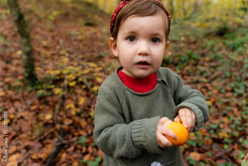Little girl eating fruit, healty snack outdoors photo