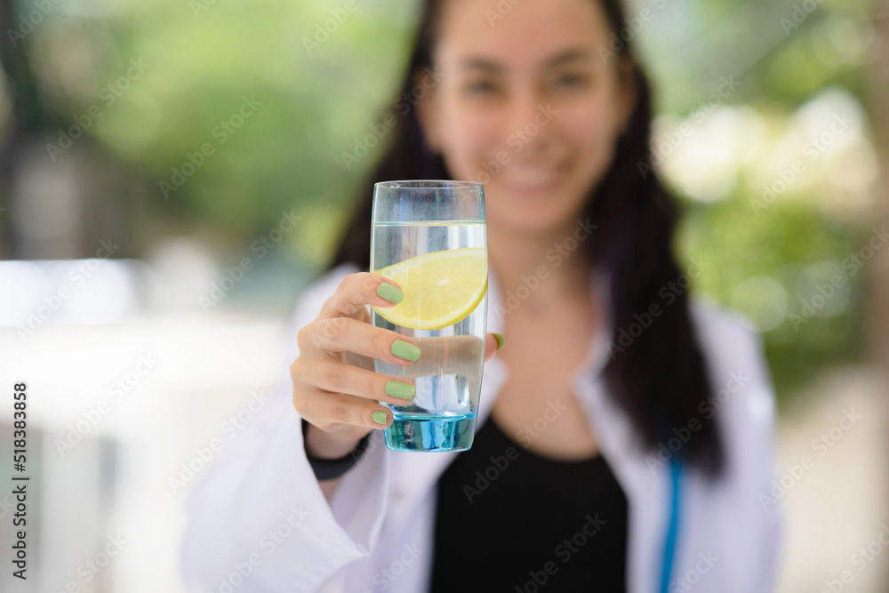Detox concept. Close up of dietitian nutritionist doctor holding a glass of water with lemon. Detox concept. Close up of dietitian nutritionist doctor holding a glass of water with lemon.
