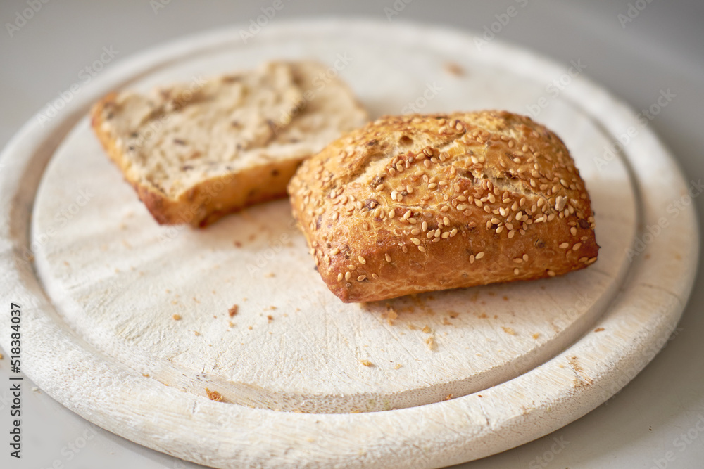 Sliced seeded wholemeal bread. Fresh brown homemade slices or roll on a wooden cutting board served as a wholesome lunch, breakfast snack meal. Healthy and organic whole wheat or grain loaf Sliced seeded wholemeal bread. Fresh brown homemade slices or roll on a wooden cutting board served as a wholesome lunch, breakfast snack meal. Healthy and organic whole wheat or grain loaf