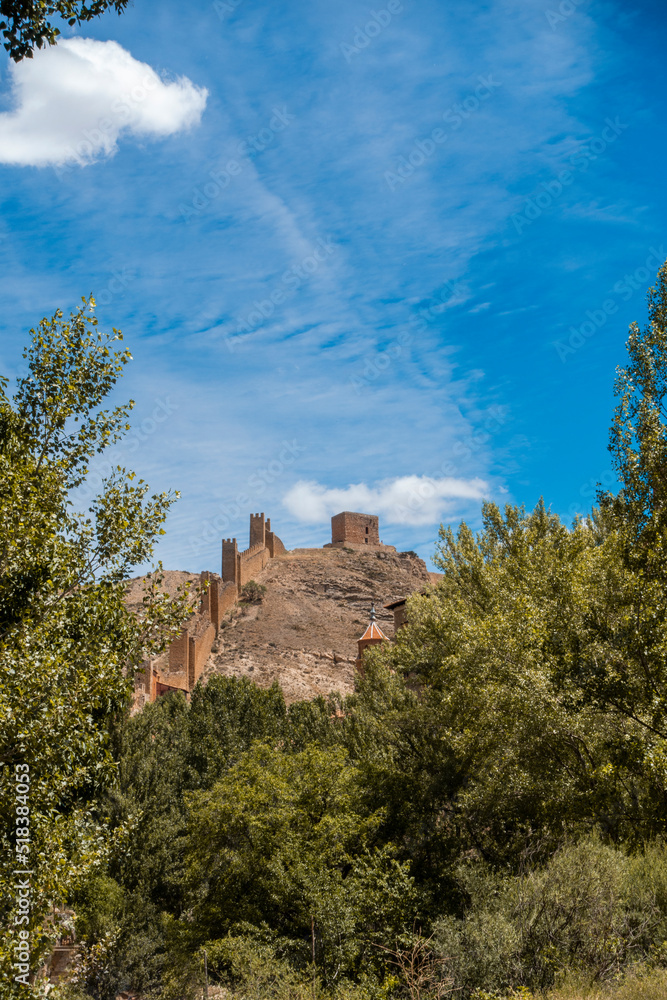 castle and wall of albarracin, historic Spanish village that overlooks the trees