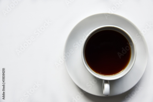 Tea pair with poured tea on a white background. Porcelain cup and saucer with tea.