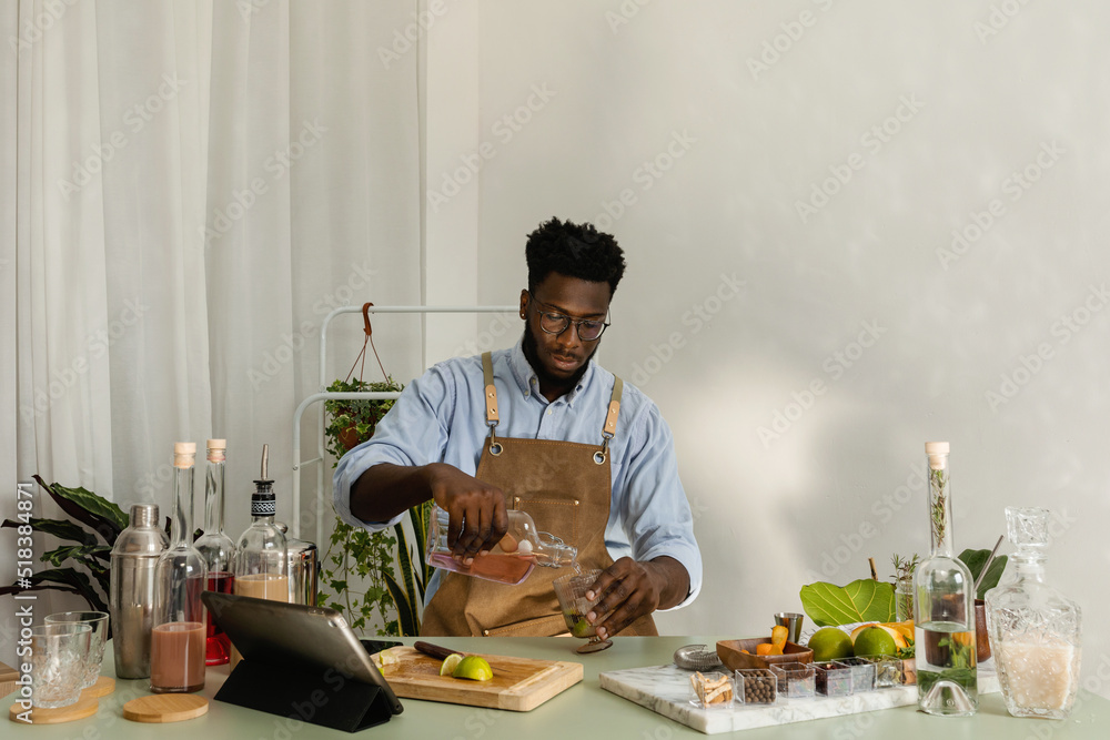 Handsome African preparing cocktails from home Handsome African preparing cocktails from home