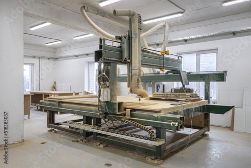 Industrial machine creating a wooden element for kraft furniture photo