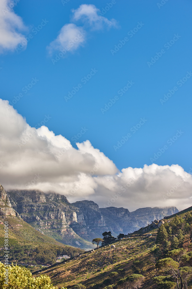 Landscape of the 12 apostles mountain range in Cape Town, South Africa looking beautiful with blue sky, white and grey clouds. Stunning view of mountains and nearby trees on a hill with copy space Landscape of the 12 apostles mountain range in Cape Town, South Africa looking beautiful with blue sky, white and grey clouds. Stunning view of mountains and nearby trees on a hill with copy space