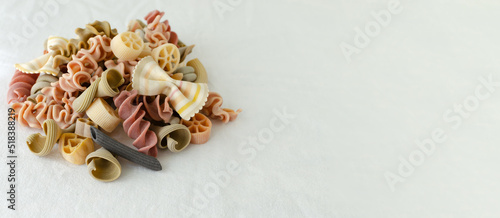 Mix of multi-colored Italian pasta on a light background. Concept alternative pasta. Horizontal orientation. copy space.