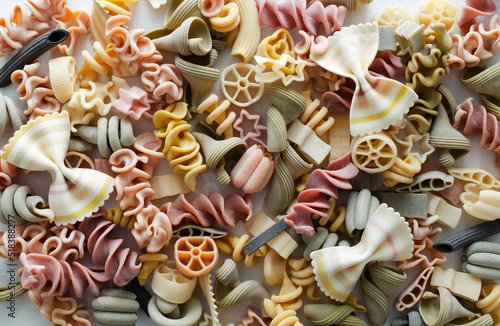 Background Mix of multi-colored Italian pasta on a light background. Concept alternative pasta. Horizontal orientation.