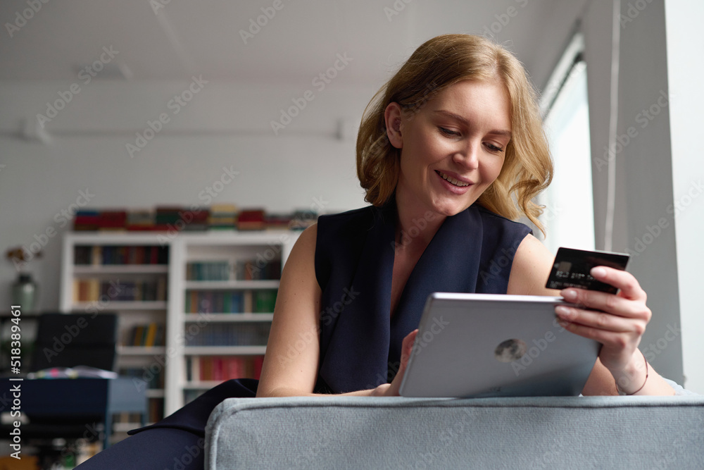 Smiling businesswoman making online payment on tablet Smiling businesswoman making online payment on tablet