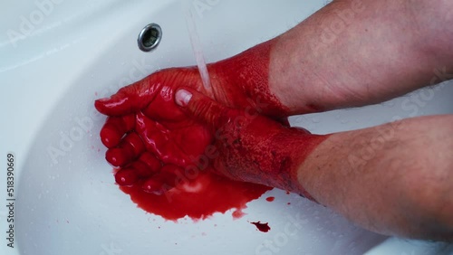 Faceless man washing hands from red liquid, paint, blood or berries under tap in sink. Male dirty arms under running water in bathroom. Butcher, worker of slaughterhouse, stockyard, butchery, killer