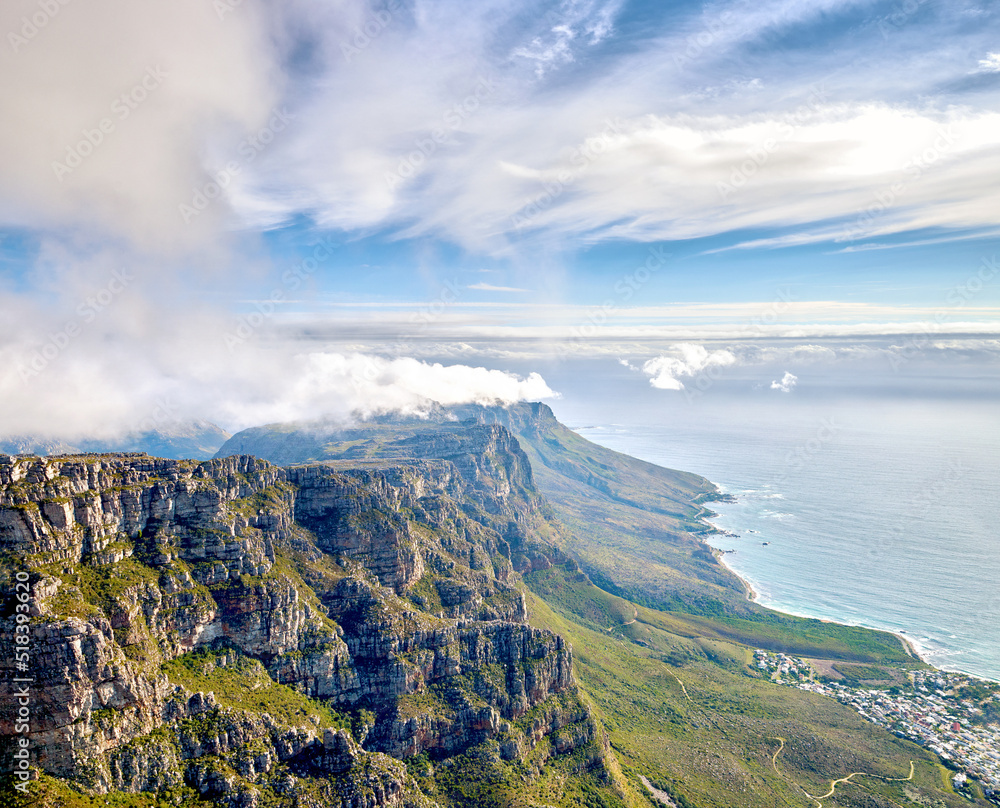 Thick clouds forming on the top of Table Mountain in Cape Town with copy space. Rocky terrain with ocean views, peaceful nature in harmony with soothing view of plants, landscape and bluewater