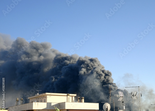 Grande nuvola di fumo nero, incendio dietro edifici in città