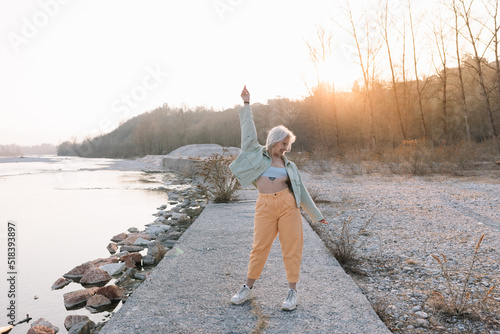 Strong Woman Dancing Near River Outdoors photo