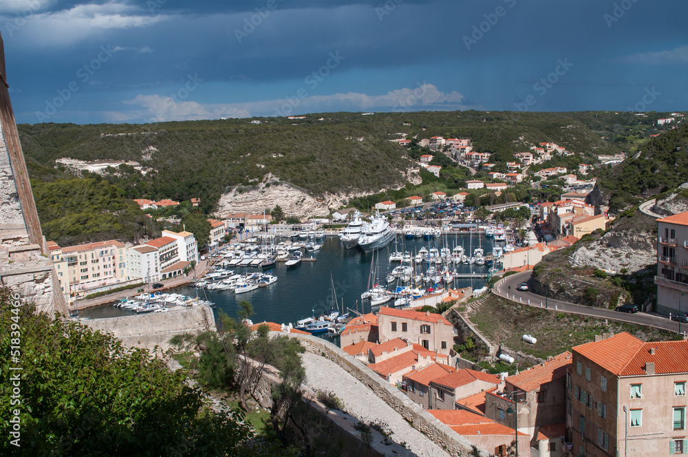 Harbor and waterfront with ships and yachts moored at sea in the town of Bonifacio on the island of Corsica in France.