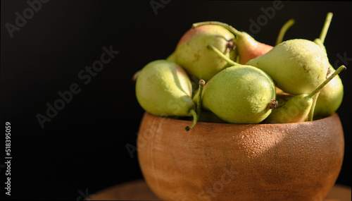 Ripe pear in a bowl on a black background