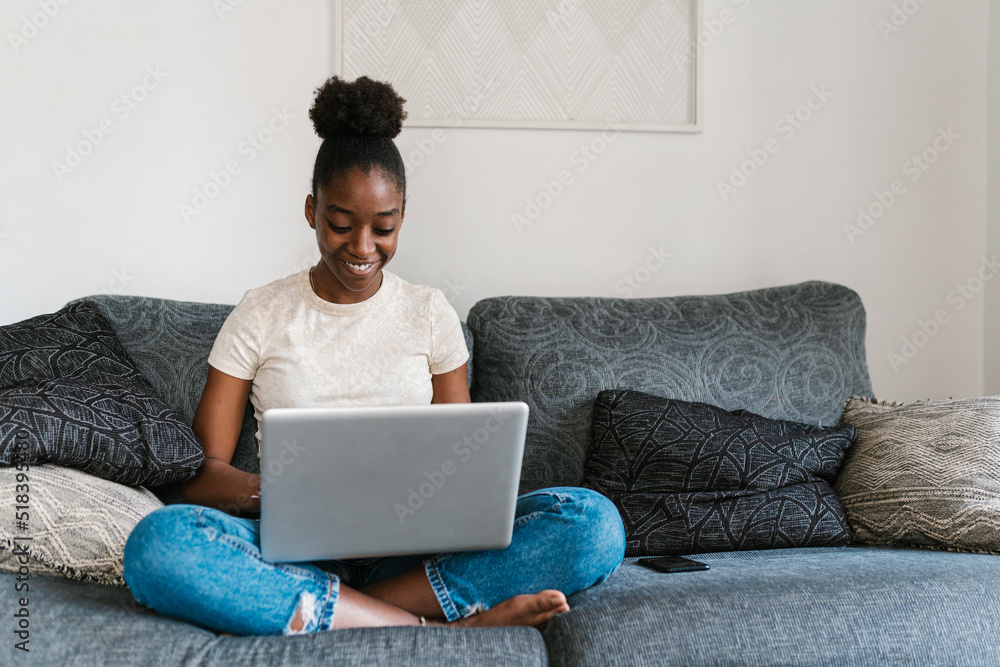 Merry African American teenager using netbook Merry African American teenager using netbook