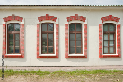 Four tall windows with brick frames in a row. Facade of one-storey building. Exterior of vintage europe building. © Олег Арюткин