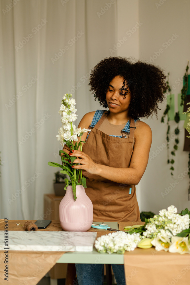 Florist owner preparing vase with flowers at work Florist owner preparing vase with flowers at work