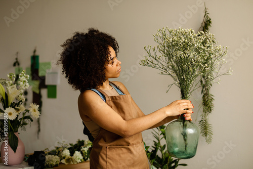 Florist decorating clear carboy with spring flowers