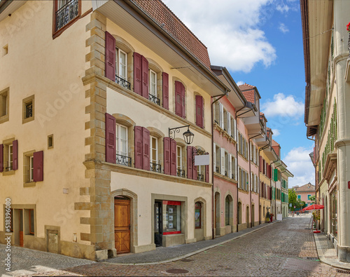 Fototapeta Naklejka Na Ścianę i Meble -  Street view of old buildings in a historic city with built medieval architecture and a cloudy blue sky in Annecy, France. Beautiful landscape of an empty small urban town with homes or houses