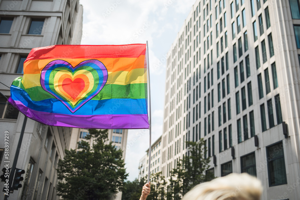 Rainbow love Pride flag with a heart carried waving through the city ...