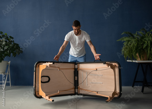 Massage therapist unfolding portable table