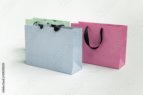 Mock-up of blank craft package, mockup of colored three paper shopping bag with black handles isolated white background
