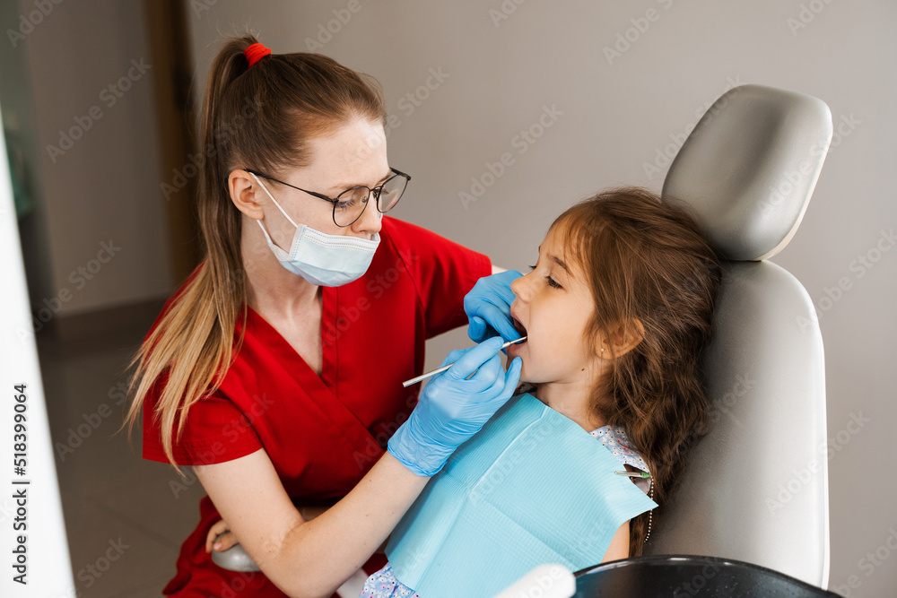 Children dentist examines child girl mouth and teeth and treats toothaches. Happy child patient of dentistry. Consultation with child dentist at dentistry. Teeth treatment. Children dentist examines child girl mouth and teeth and treats toothaches. Happy child patient of dentistry. Consultation with child dentist at dentistry. Teeth treatment.