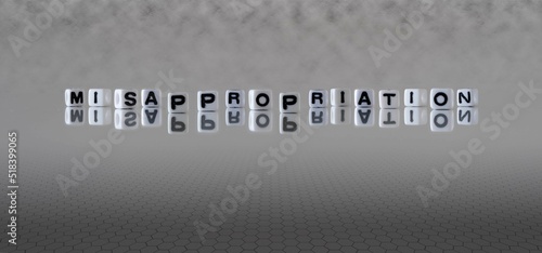 misappropriation word or concept represented by black and white letter cubes on a grey horizon background stretching to infinity photo