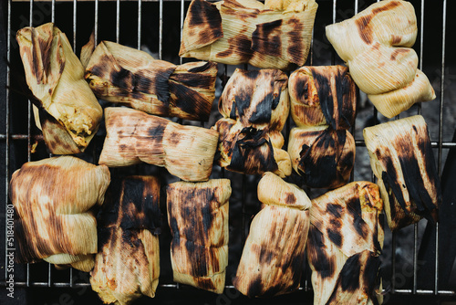 toasted homemade chilean humitas on the grill. Ground corn mix wrapped in corn husks and boiled photo