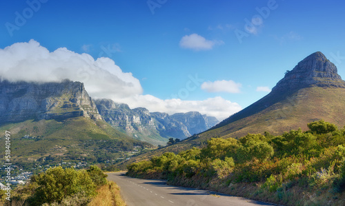 A road leading to Lions Head, Table mountain and the Twelve Apostles in Cape Town, South Africa. Peaks and lush green landscape on a sunny, peaceful morning with beautiful scenic views and copy space