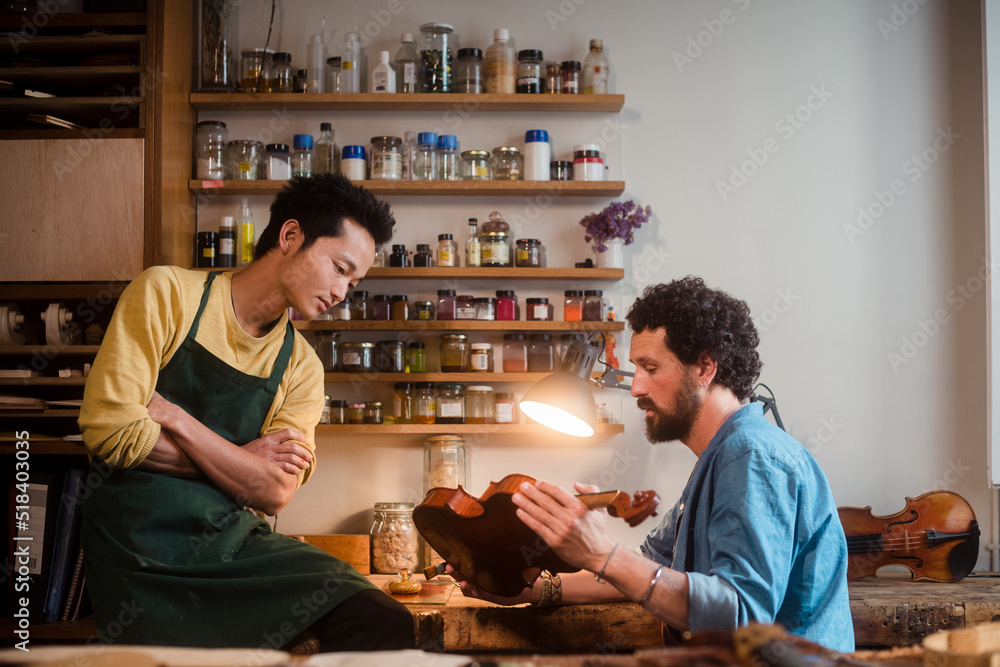 Two violin luthiers discussing about best restoration approach Two violin luthiers discussing about best restoration approach