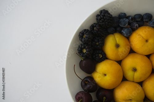 Variety of fresh berries and organic summer fruit on light background. Healthy food.