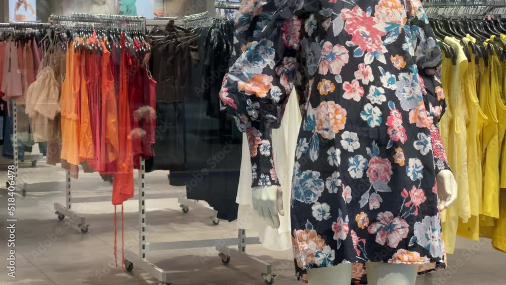 Women's clothing store with a summer collection. Multicolored dresses hang on hangers Women's clothing store with a summer collection. Multicolored dresses hang on hangers