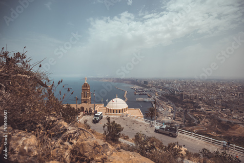 Panoramic view of blessed virgin mary church from Santa Cruz fortress, one of the three forts in Oran, the second largest port of Algeria; Summer day, looking from high above towards the city. photo