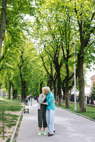 Wallpaper Mural  Woman embracing and kissing girlfriend during walk outside town  Torontodigital.ca