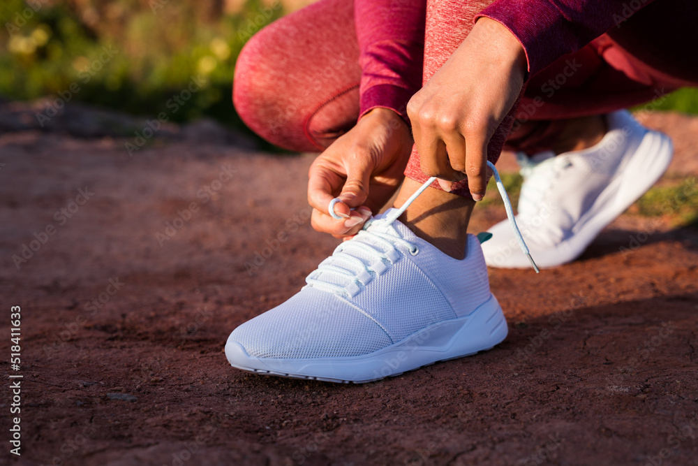 Caucasian woman tie her laces at the shoes while preparing to the morning run