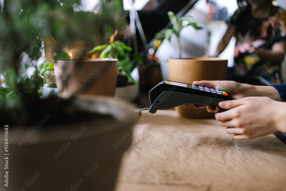 Faceless employee checking payment on contactless terminal Faceless employee checking payment on contactless terminal
